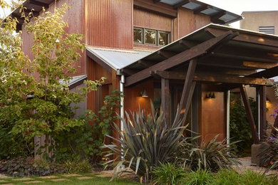 Inspiration for a large industrial brown two-story metal exterior home remodel in San Francisco with a butterfly roof
