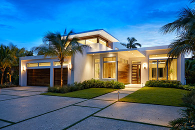 Inspiration for a large modern white two-story stucco exterior home remodel in Miami with a green roof