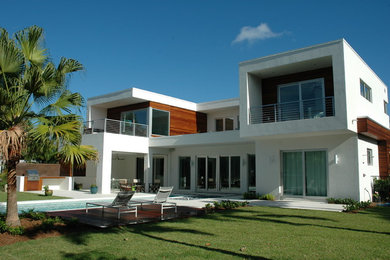 Exempel på ett mellanstort modernt vitt hus, med två våningar, stuckatur och platt tak