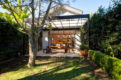 Diseño de fachada de casa gris contemporánea pequeña de tres plantas con revestimiento de ladrillo, tejado a dos aguas y tejado de metal
