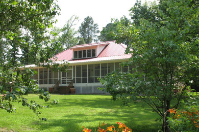 Ejemplo de fachada de casa blanca campestre de tamaño medio de una planta con revestimiento de aglomerado de cemento, tejado a cuatro aguas y tejado de metal