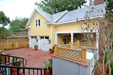 Mid-sized arts and crafts yellow two-story vinyl exterior home photo in Orlando with a clipped gable roof