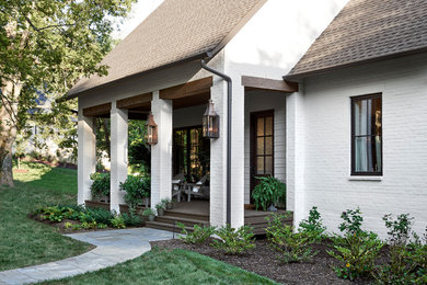 Example of a mid-sized transitional white brick gable roof design in Nashville