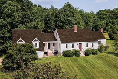 Modelo de fachada de casa blanca de estilo de casa de campo grande de una planta con revestimiento de vinilo, tejado a dos aguas y tejado de teja de madera
