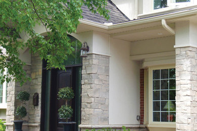 Large and beige traditional two floor house exterior in Toronto with stone cladding.