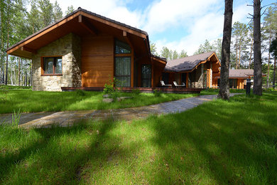 Ejemplo de fachada marrón contemporánea grande con revestimiento de madera y tejado a dos aguas