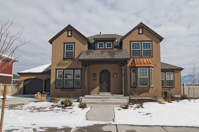 На фото: большой, двухэтажный, коричневый дом в классическом стиле с облицовкой из цементной штукатурки и двускатной крышей с