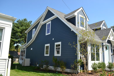 Ejemplo de fachada de casa azul tradicional de tamaño medio de dos plantas con revestimiento de aglomerado de cemento, tejado a dos aguas y tejado de teja de madera