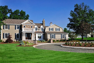 Diseño de fachada beige clásica grande de dos plantas con revestimiento de madera y tejado a dos aguas