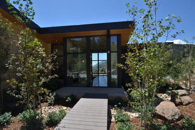 Cette photo montre une façade de maison moderne à un étage avec un revêtement mixte et un toit en appentis.