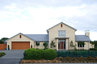 Ejemplo de fachada de casa beige moderna de tamaño medio de dos plantas con revestimientos combinados, tejado a cuatro aguas y tejado de metal