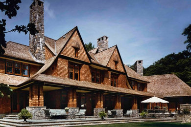 Imagen de fachada de casa marrón rural extra grande de dos plantas con revestimiento de madera, tejado a dos aguas y tejado de teja de madera