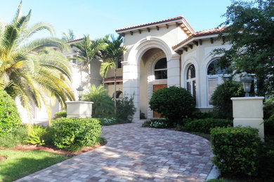 Large mediterranean beige two-story stucco exterior home idea in Miami with a hip roof