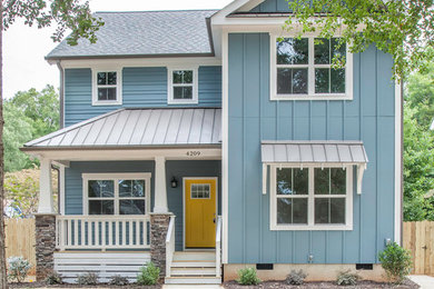 Imagen de fachada de casa azul costera de dos plantas con revestimiento de vinilo y tejado de varios materiales