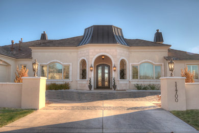 Inspiration for a large mediterranean beige one-story stucco exterior home remodel in Albuquerque with a hip roof