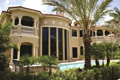 Inspiration for a large mediterranean beige two-story house exterior remodel in Miami