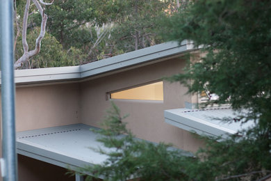 Réalisation d'une grande façade de maison beige minimaliste à un étage avec un revêtement mixte.