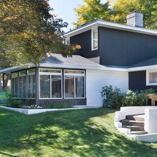 Inspiration for a 1950s brown two-story mixed siding exterior home remodel in Boston with a hip roof