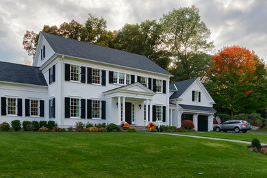Imagen de fachada de casa blanca clásica grande de dos plantas con revestimiento de madera, tejado a dos aguas y tejado de teja de madera