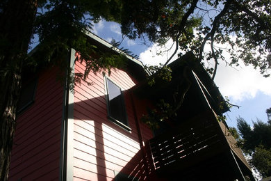 Modelo de fachada roja clásica renovada de tamaño medio de dos plantas con revestimiento de aglomerado de cemento y tejado a dos aguas