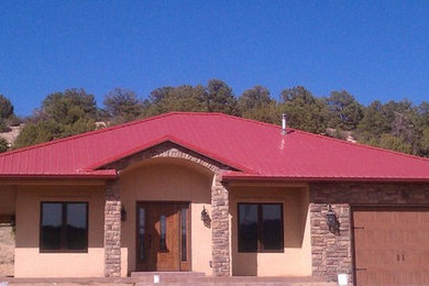 Example of a mid-sized southwest beige one-story stucco exterior home design in Denver with a hip roof