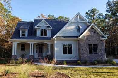 Aménagement d'une façade de maison grise contemporaine de taille moyenne et à un étage avec un revêtement mixte, un toit à deux pans et un toit en shingle.