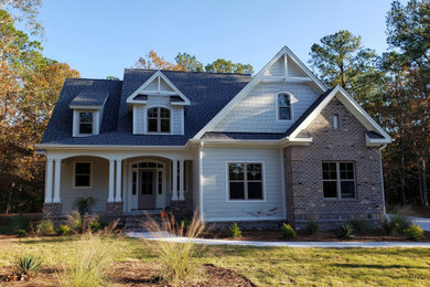 This is an example of a medium sized and gey contemporary two floor detached house in Other with mixed cladding, a pitched roof and a shingle roof.