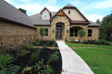 Inspiration for a large timeless brown two-story stone house exterior remodel in Houston with a shingle roof, a gray roof and a clipped gable roof