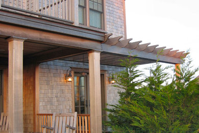 Imagen de fachada de casa gris de estilo americano grande de dos plantas con revestimiento de madera y tejado a cuatro aguas