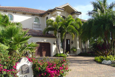 This is an example of a large and beige mediterranean two floor render house exterior in Tampa.