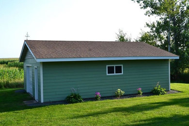 Ejemplo de fachada verde tradicional de tamaño medio de una planta con revestimiento de vinilo, tejado a dos aguas y tejado de teja de madera