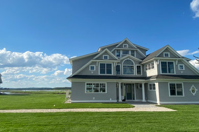 Huge beach style gray three-story wood house exterior photo in Portland Maine with a shed roof and a shingle roof