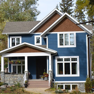 Modelo de fachada de casa azul, de estilo americano, de tamaño medio, de dos plantas, con revestimiento de aglomerado de cemento, tejado a dos aguas y tejado de teja de madera