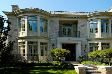 Diseño de fachada beige ecléctica grande de dos plantas con revestimiento de ladrillo