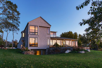Cette image montre une façade de maison grise minimaliste en bois.