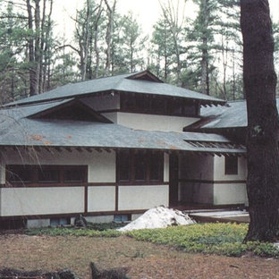 Photo of a large asian two-storey stucco white house exterior in Other with a shingle roof.