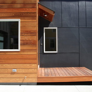 Foto de fachada de casa gris, actual, de tamaño medio, de dos plantas, con revestimientos combinados, tejado a dos aguas y tejado de teja de madera