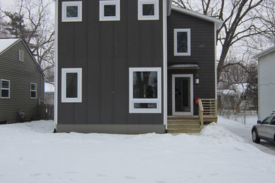Diseño de fachada gris actual de dos plantas con revestimiento de aglomerado de cemento