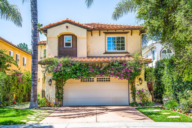 Tuscan beige two-story house exterior photo in Los Angeles with a hip roof and a tile roof