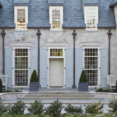 Example of a mid-sized classic gray two-story stone house exterior design in Charlotte with a hip roof and a shingle roof