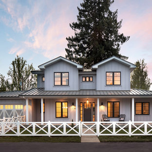 Diseño de fachada de casa blanca, de estilo de casa de campo, grande, de tres plantas, con tejado de metal, tejado a cuatro aguas y revestimiento de madera