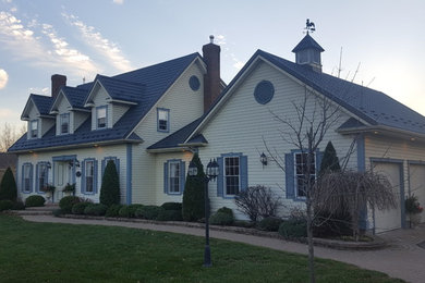 オタワにある高級なトラディショナルスタイルのおしゃれな家の外観 (ビニールサイディング、黄色い外壁) の写真