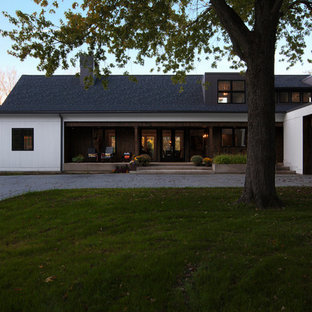 Ejemplo de fachada de casa blanca, de estilo de casa de campo, de tamaño medio, de dos plantas, con revestimiento de madera, tejado a dos aguas y tejado de teja de madera