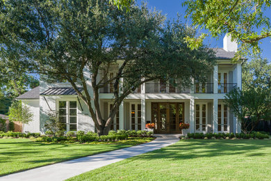 Inspiration for a large timeless white two-story brick house exterior remodel in Dallas with a hip roof and a shingle roof