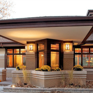 This is an example of a mid-sized asian brick brown house exterior in Chicago with a hip roof and a shingle roof.