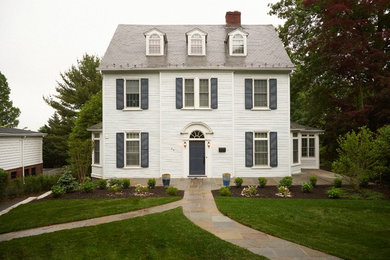 Aménagement d'une façade de maison blanche en panneau de béton fibré de taille moyenne et à deux étages et plus avec un toit à deux pans.