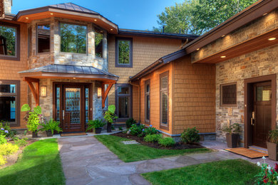 Foto de fachada de casa marrón de estilo americano grande de dos plantas con revestimientos combinados, tejado a cuatro aguas y tejado de varios materiales