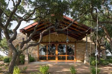 Large and brown industrial bungalow house exterior in Austin with stone cladding and a pitched roof.