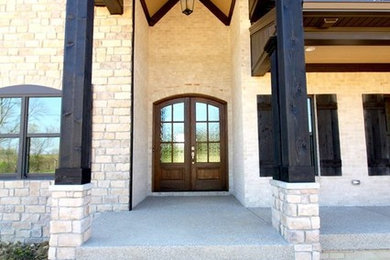 Inspiration for a large transitional beige one-story stone gable roof remodel in Louisville
