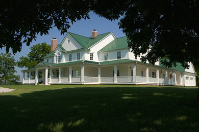 Ejemplo de fachada de casa blanca clásica grande de dos plantas con revestimiento de madera, tejado a dos aguas y tejado de metal